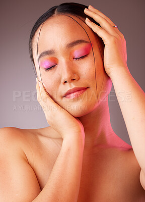 Buy stock photo Eyeshadow, asian and beauty woman with hands on face pose with pink and orange cosmetics. Funky, trendy and colorful fashion makeup model for Gen Z cosmetic style on grey studio background.