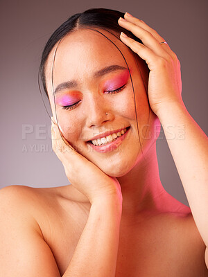 Buy stock photo Face, beauty and makeup with a model asian woman touching her skin with her hands in studio on a gray background. Skincare, cosmetics and wellness with a young female posing to promote skin health