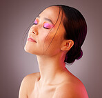 Beauty, makeup and woman with neon cosmetics on her face against a grey mockup studio background. Relax, calm and Asian model with peace from luxury pink facial cosmetic and skincare wellness