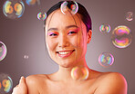 Cosmetics, bubbles and Asian woman for smile, happy or skincare for health, wellness or studio background. Portrait, young girl or makeup for body care, natural beauty or happiness for organic facial