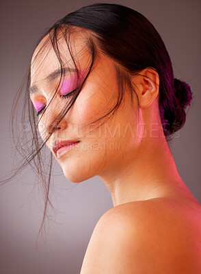 Buy stock photo Neon makeup, creative and face of a woman against a grey studio background. Relax, wellness and Asian cosmetics model with luxury facial product for body beauty, cosmetic art and glow from eyeshadow