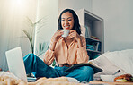 Laptop, coffee and bed with a woman blogger sitting in her bedroom while browsing the internet. Computer, email and drink with a young female freelance employee working from home in the morning