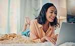 Bed, laptop and relax with a woman blogger or freelance worker doing remote work from home while lying in the bedroom. Computer, email and technology with a female working on her black in a house