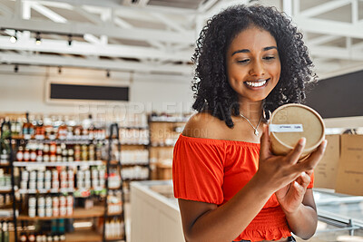 Buy stock photo Supermarket, black woman and shopping, groceries and happy with product in retail shop, customer check ingredients. Grocery store, sale on food and drink, happiness with shop choice and buying.