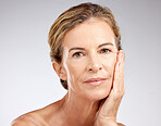 Face, beauty and antiaging with a mature woman in studio on a gray background for skincare or wellness. Cosmetics, health and treatment with a senior female posing to promote a natural product