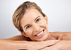 Senior woman, relax and beauty for skincare with smile for cosmetics, facial or treatment against a grey studio background. Portrait of happy elderly female face relaxing and smiling for moisturizer