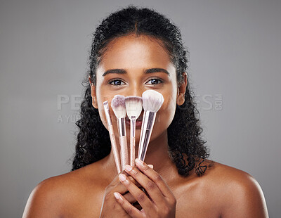 Buy stock photo Makeup, beauty and portrait of black woman with brushes for beauty products, skincare products and foundation. Skincare, facial and happy girl with cosmetics makeup brushes on gray background studio