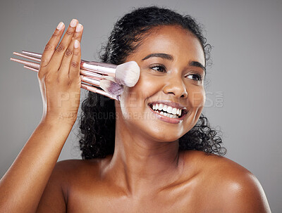 Buy stock photo Beauty, face makeup and woman with brush to apply luxury skincare, anti aging or facial cosmetics product. Wellness, self care and happy Indian girl with smile, health and makeup brush for foundation