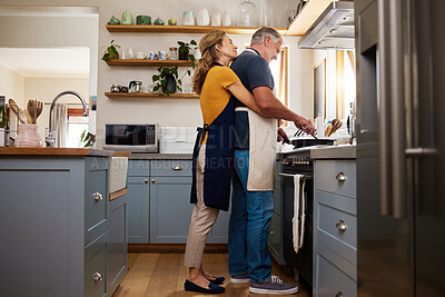 Buy stock photo Love, food and elderly couple cooking in a kitchen, hug and bond while preparing a meal in their home together. Happy family, retirement and mature man and woman embrace while preparing a meal 