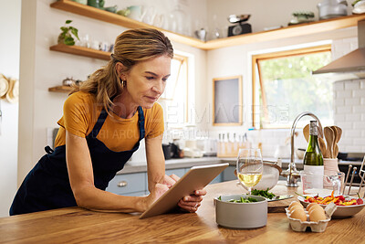 Buy stock photo Woman, tablet and kitchen for online recipe, browsing or research in cooking or baking at home. Female with apron checking instructions on the internet for meal or ingredients on touchscreen indoors