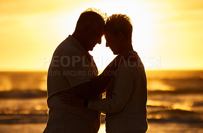 Buy stock photo Couple, elderly and silhouette at beach with hug in sunset, evening or dusk by water, waves or horizon together. Senior, man and woman by ocean, sea or sunshine for care, affection or love in romance