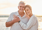Love, travel and beach portrait with senior couple hug, bond and relax at sunset, happy and cheerful in nature. Smile, elderly and man with woman embracing on ocean trip, hugging and enjoy vacation