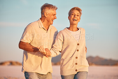 Buy stock photo Retirement, couple and being playful outdoor, walking or on beach being loving, together or happy marriage. Love, senior man and mature woman with smile, embrace and holding hands and seaside bonding