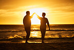 Love, ocean and sunset, silhouette of couple on beach holding hands in Bali. Waves, romance and man and woman dancing in evening sun on romantic vacation spending time together in nature and sea sand