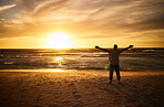 Freedom, beach and man silhouette celebration at sunset, happy and success in nature. Motivation, health, and energy challenge winner by a guy shadow cheering and express victory, happiness and joy
