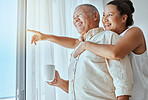 Mature couple, hug or pointing out window in house, home or retirement holiday hotel with morning coffee. Smile, happy or elderly man and love woman in show hand gesture at bonding travel hospitality