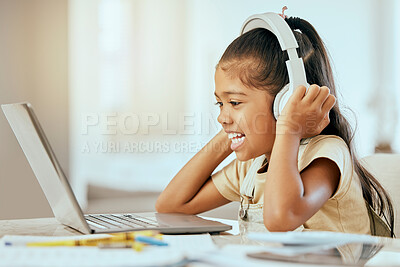 Buy stock photo Girl, laptop and headphones with smile, music or video on desk in homeschool, learning and education, Child, computer and happy for podcast on internet, web or app by table in house for online class
