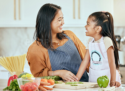 Buy stock photo Happy family, mother girl cooking food for a healthy vegan diet with spaghetti and vegetables at home. Smile, development and child loves helping mom or mama in the house kitchen with lunch or dinner