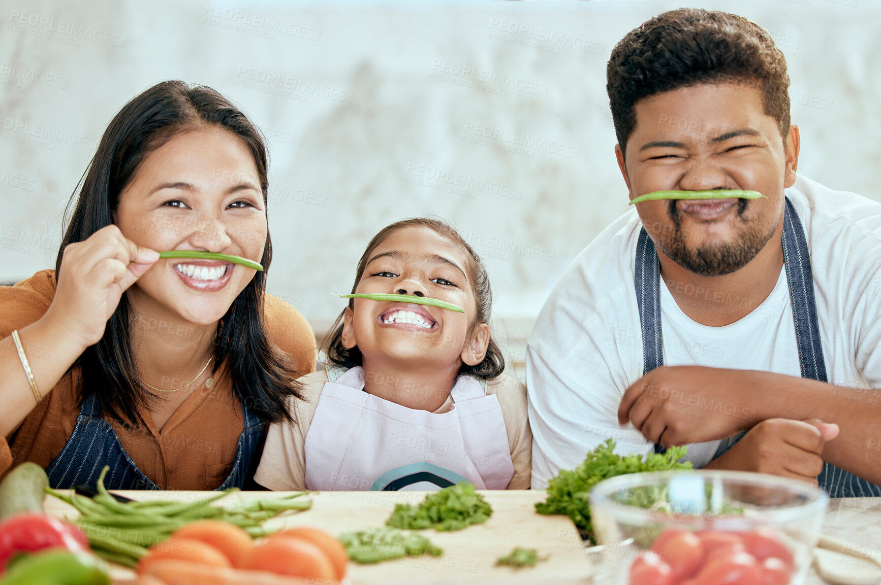 Buy stock photo Asian, family and vegetables for playing in kitchen for portrait at table, happy or together. Mom, dad and child with smile in home at counter for health, food or nutrition in diet, dinner or cooking