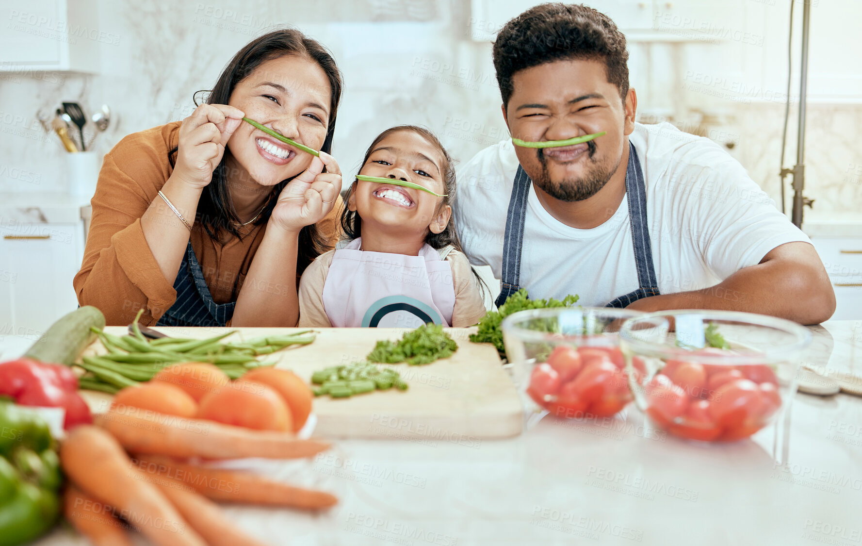 Buy stock photo Cooking, family and comic portrait in kitchen for crazy, goofy and silly fun together with smile. Food, asian and bonding with funny vegetable face of happy mother, father and child in house.

