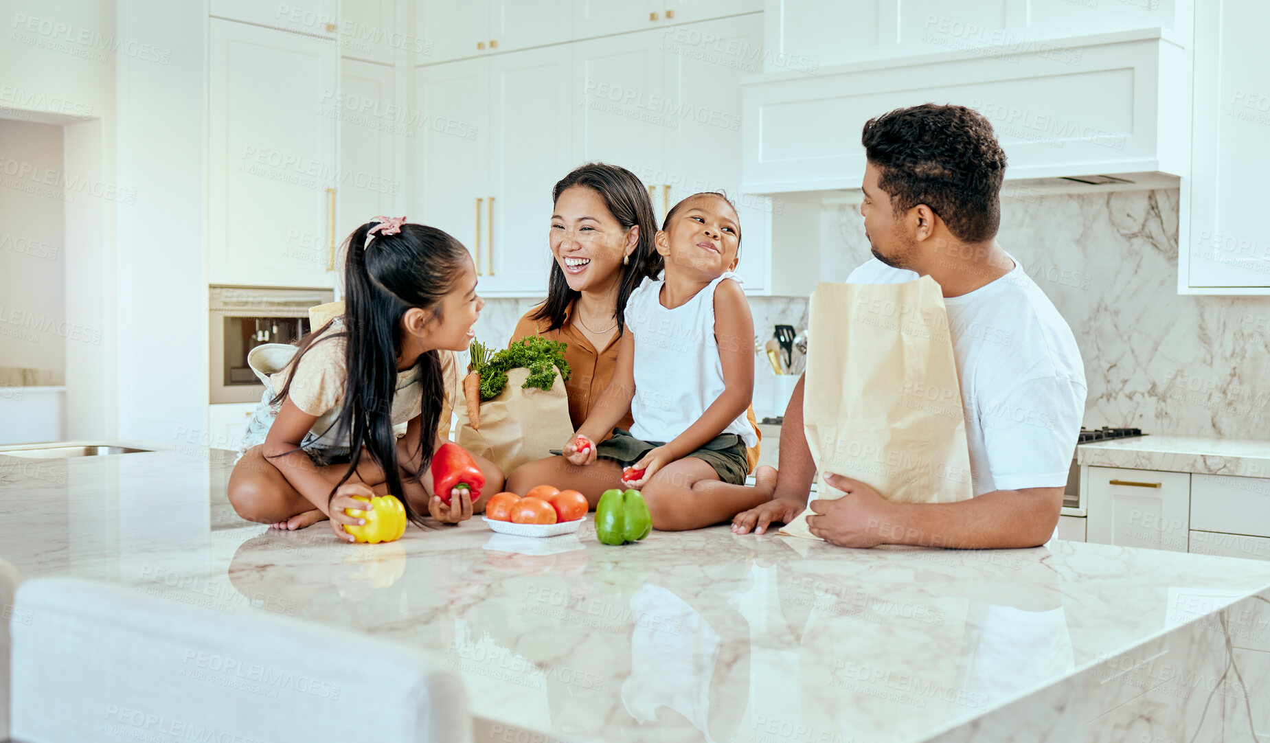 Buy stock photo Asian, family and vegetables in kitchen for laugh at table, happy or comic in bonding. Mom, dad and children with smile at counter for funny, joke or crazy with bags after shopping in home in Jakarta