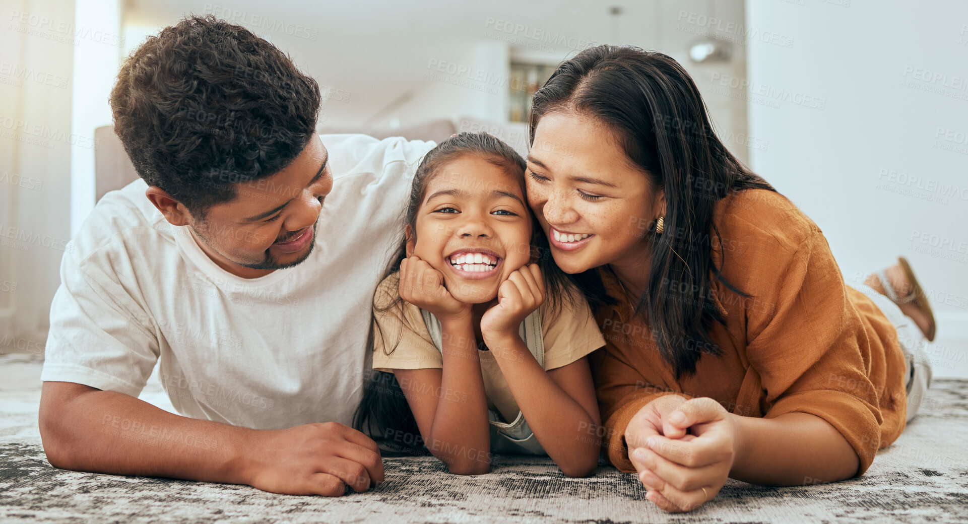 Buy stock photo Family, lying on floor and parents with child, together and happy while bonding at family home. Playful, love and care with mother, father and girl kid, smile in portrait while spending quality time.