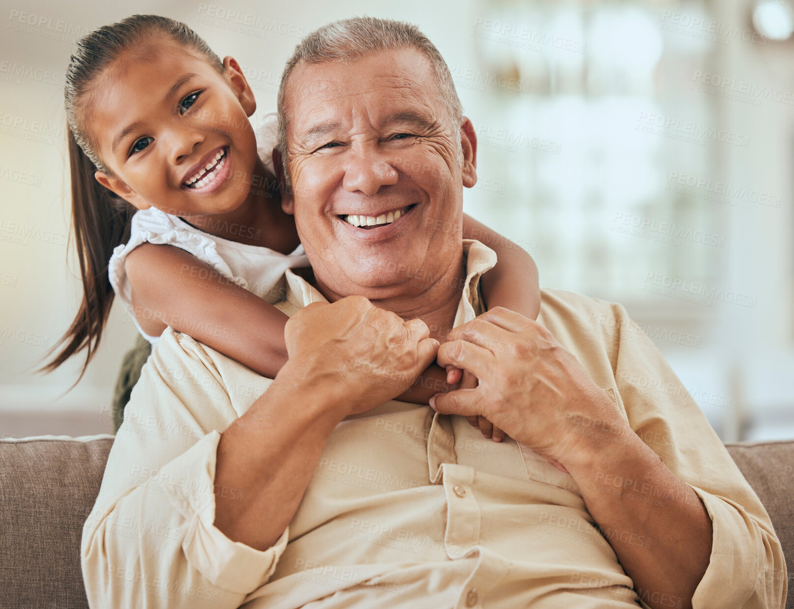 Buy stock photo Grandfather, child and portrait with hug in home lounge to bond with young and cute grandchild. Family, elderly and senior grandpa in Indonesia holding kid with happy smile on sofa in house.

