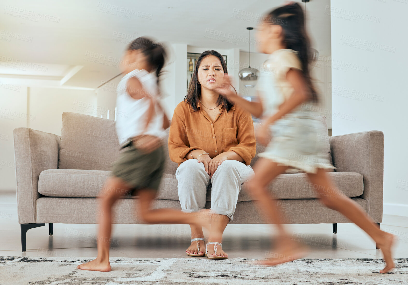 Buy stock photo Child care stress, mother and children running with energy with mom feeling anxiety on a home sofa. Mama burnout, kids and fast siblings run in the living room lounge with tired mom on the couch