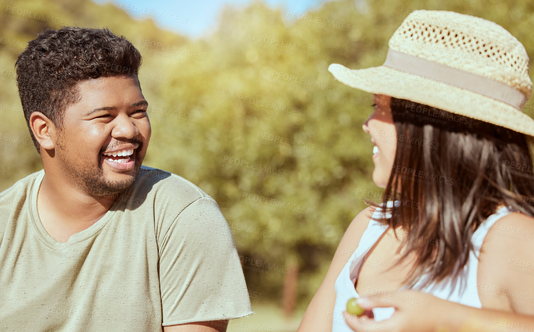 Buy stock photo Happy, love and couple in nature in a conversation while on an outdoor garden picnic date in summer. Happiness, communication and young man and woman with a smile talking in a park to relax together.