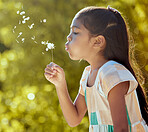 Girl, child and nature dandelion flower blowing for wish, dream and magic in garden on vacation in spring. Kid, park and motivation for hope, love and earth seed outdoor to relax for happy youth