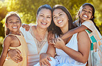 Women, happy and nature park of a family together with a smile and hug bonding outdoor. Portrait of a mother, grandparent and girl siblings with happiness, love and care feeling positive in the sun