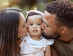 Mother, father and baby face kiss while bonding in a garden outdoors with love, care and affection. Loving, caring parents kissing little daughter while bond in nature for calm relaxation