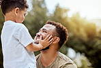 Dad, boy touch face in outdoor park or backyard for summer bonding, happiness together and sunshine. Father son, happy black man in nature for love smile and quality time with child in Los Angeles