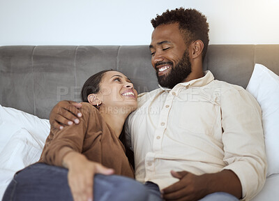 Buy stock photo Love, relax and couple in bed in their home, resting and smiling while talking and bonding in bedroom together. Black family, resting and comfort with smile, happy and laughing man and woman embrace