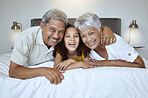 Girl, grandparents and relax on bed with smile, happy and love with family bonding together in home. Portrait on latino child, senior man and woman laugh, joy and fun together in bedroom on a weeknd