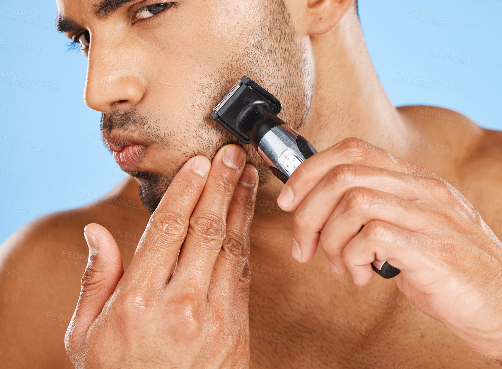 Buy stock photo Beauty, skincare and man shaving beard in his grooming routine with an electric machine in a studio in Mexico. Wellness, Latino and healthy male model shaves his facial hair with a cool modern razor