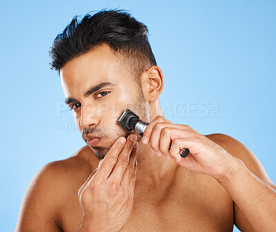 Buy stock photo Man, beauty and shaving for facial grooming in skincare for fresh clean hygiene against a blue studio background. Male shave beard with razor in cosmetics, face and care treatment for healthy skin