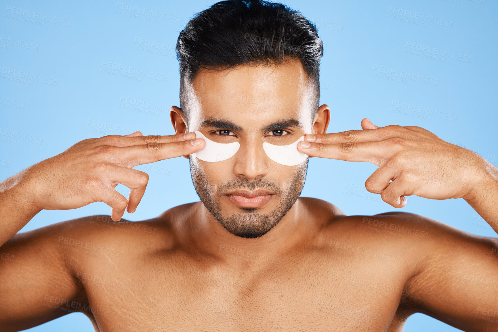 Buy stock photo Man, eye patches and beauty for skincare, cosmetics or facial products against a blue studio background. Portrait of isolated male model in care for eyes applying patch for healthy skin or treatment