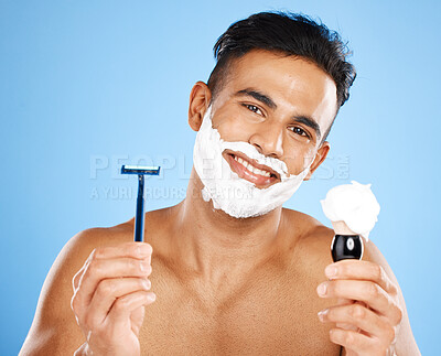 Buy stock photo Man, razor and cream for skincare shaving, grooming or facial treatment against a blue studio background. Portrait of happy and satisfied male holding equipment for shave, beauty or clean hygiene