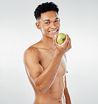 Apple, body and diet with a model black man posing in studio on a gray background for healthy eating. Portrait, fruit and health with a handsome young male inside to promote a natural or green diet
