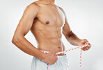 Man, measuring tape with weightloss and diet, body wellness and healthy lifestyle, weight check with bare abdomen. Fitness, health and muscle, shirtless and abs with fat or slim in studio background.