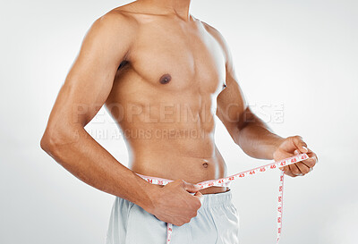 Buy stock photo Man, measuring tape with weightloss and diet, body wellness and healthy lifestyle, weight check with bare abdomen. Fitness, health and muscle, shirtless and abs with fat or slim in studio background.