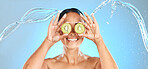 Kiwi fruit, woman and beauty water splash for natural cosmetics, facial mask and healthy skincare product on studio blue background. Happy model face, organic self care dermatology and clean wellness