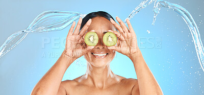 Buy stock photo Kiwi fruit, woman and beauty water splash for natural cosmetics, facial mask and healthy skincare product on studio blue background. Happy model face, organic self care dermatology and clean wellness