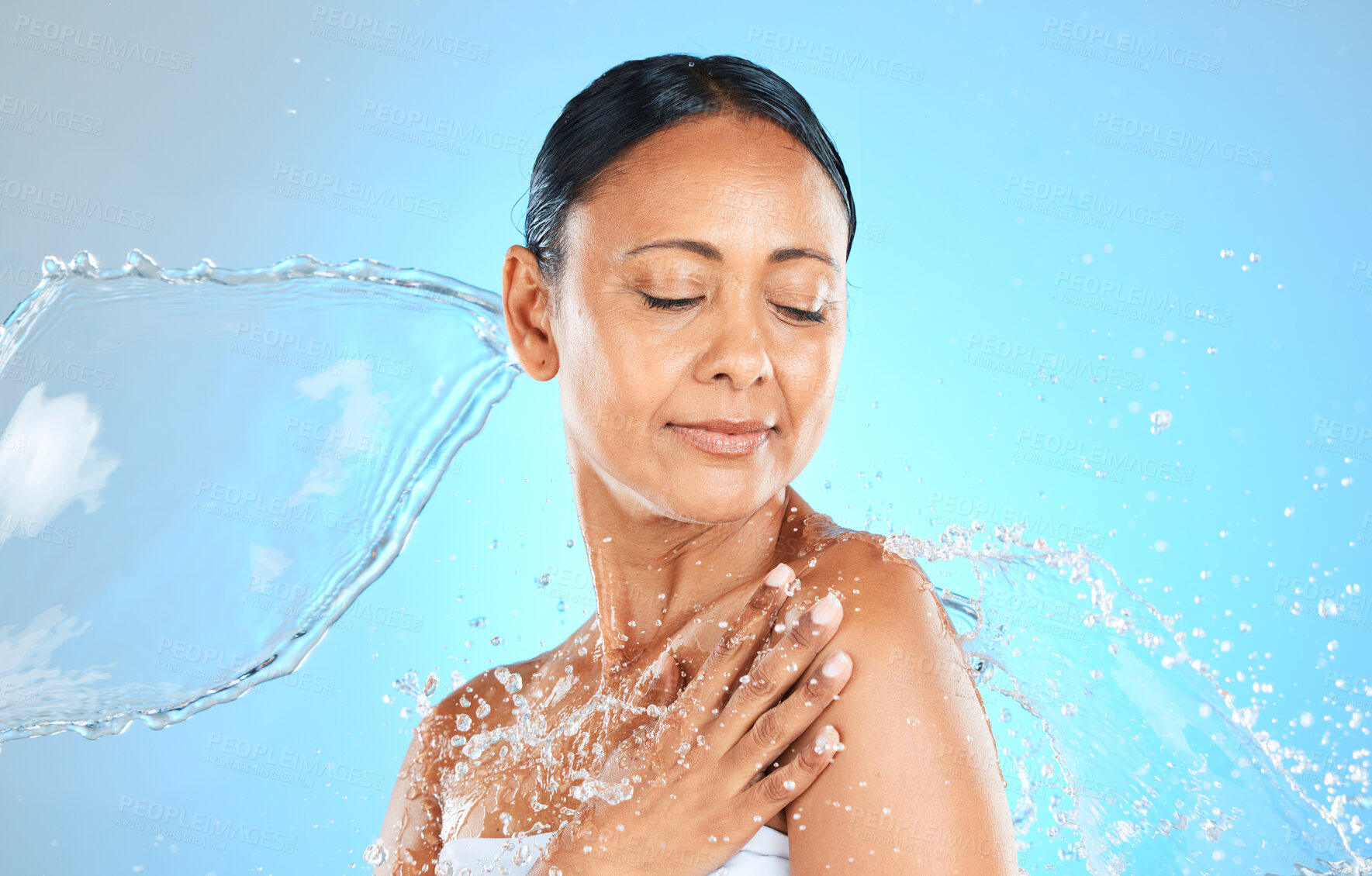 Buy stock photo Beauty, skincare and splash with water and woman for shower, wellness or spa. Relax, refreshing or water with model against blue background for hydration, luxury or hyaluronic acid moisture cosmetics