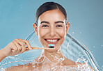 Woman brushing teeth, water splash and toothbrush, toothpaste and dental cleaning of mouth wellness on blue background in studio shower Portrait face of healthy teeth, big smile or facial beauty care