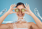 Woman, shower and kiwi for beauty, skincare and eye treatment in a studio with mockup and blue background. Fruit, water and wellness girl model relax, happy and smile with organic, shower and product