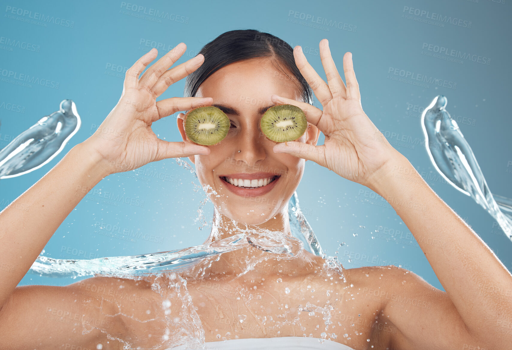 Buy stock photo Woman, shower and kiwi for beauty, skincare and eye treatment in a studio with mockup and blue background. Fruit, water and wellness girl model relax, happy and smile with organic, shower and product