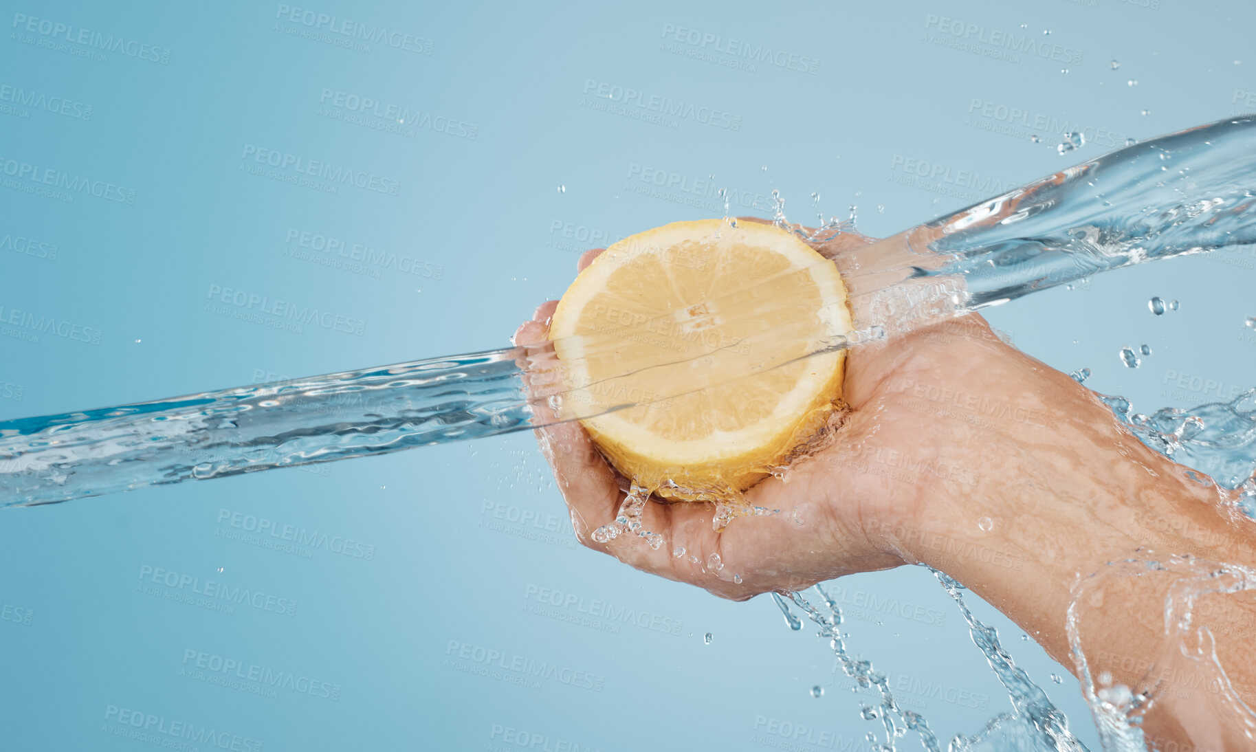 Buy stock photo Water, splash and beauty with hands and lemon for health, wellness and hydration. Vitamin c, refreshing or nutrition with citrus fruits and model against blue background for natural, vitality or diet