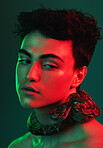 Beauty light, snake and face of model with creative color fashion, red neon lighting and luxury facial skincare. Creativity, individuality and aesthetic man with python on green studio background